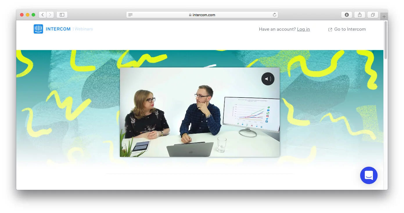 A webinar page playing a video of two hosts at a table discussing a line chart on the monitor beside them