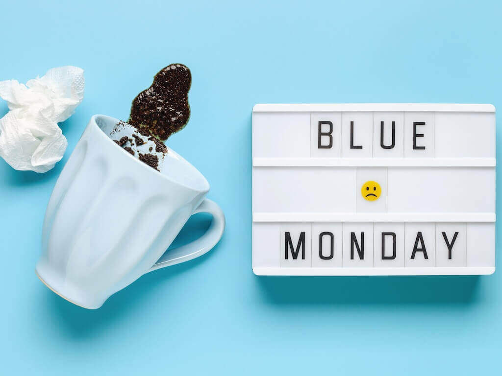 Spilled coffee and Blue Monday sign symbolizing low engagement at the start of the week