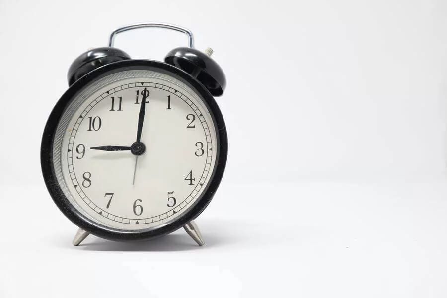 A black alarm clock on a white background