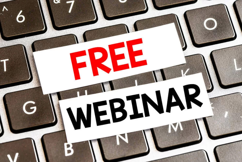 Смужки паперу зі словами free і webinar лежать на клавіатурі