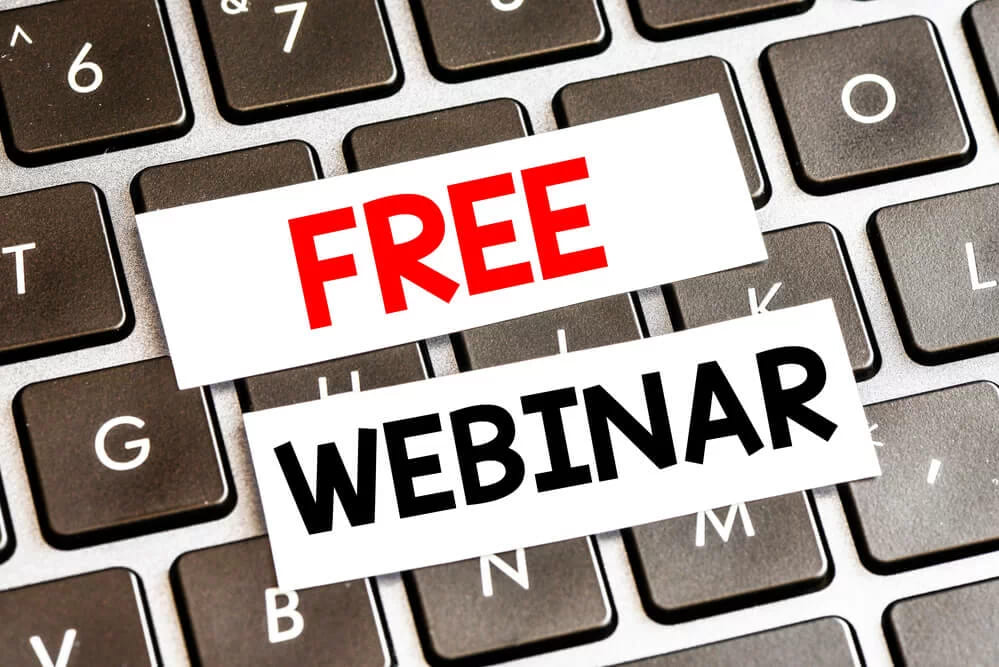 Две бумажные полоски на клавиатуре со словами free и webinar