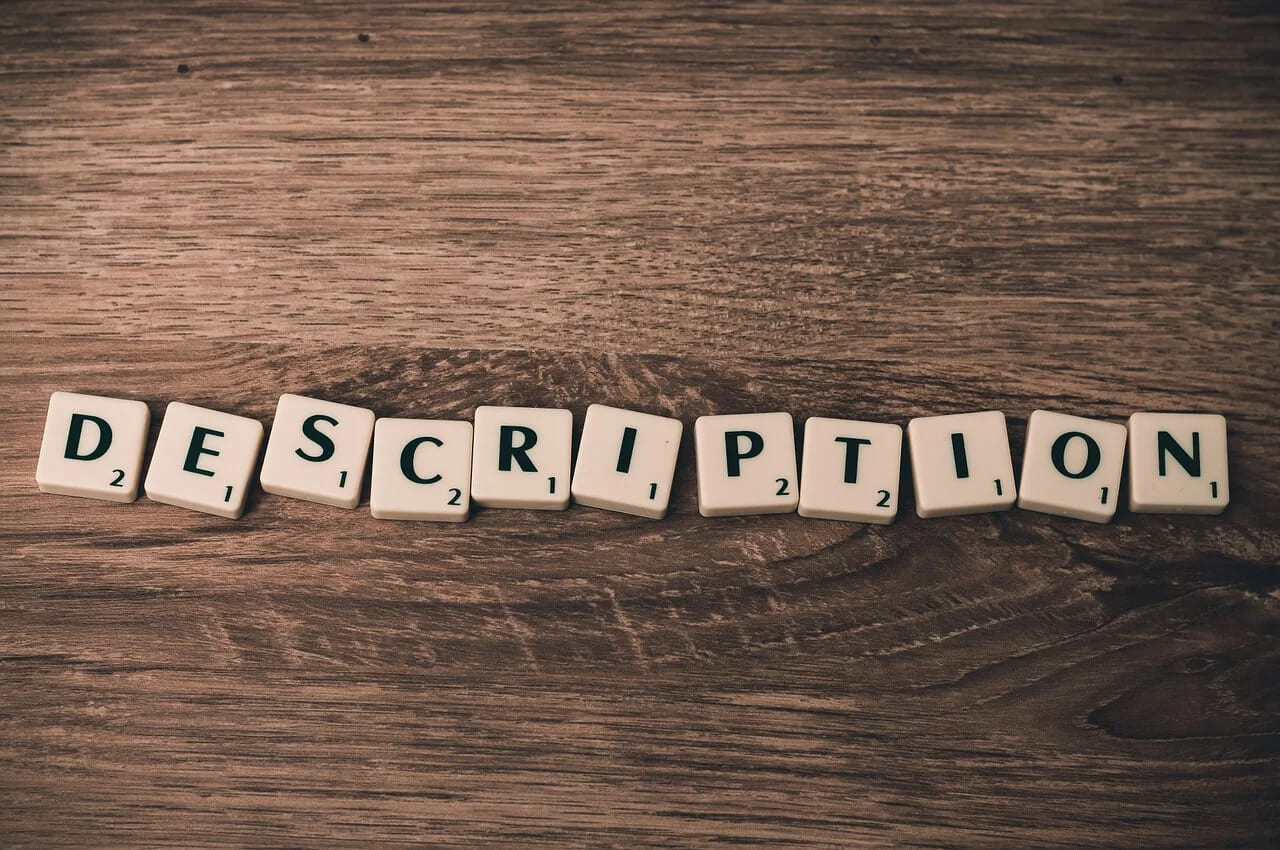 Scrabble tiles spelling the word description on a dark wooden table