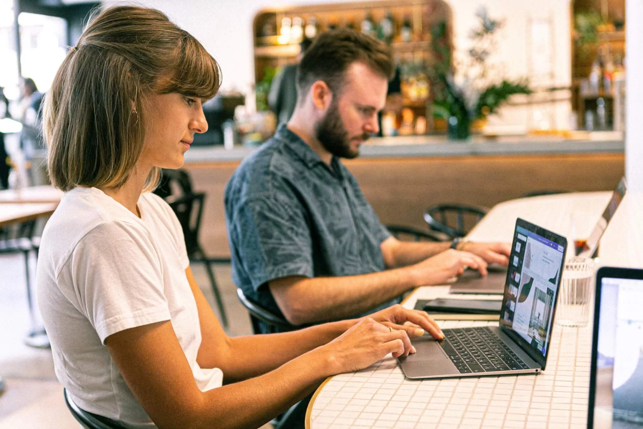 People collaborating on laptops in office setting while organizing a webinar